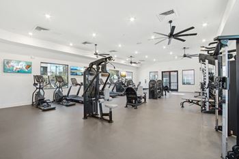 a gym with weights and cardio equipment in a building with white walls  at The Maddox Luxury Apartment Homes, Arizona, 85326